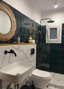 La salle de bains est pourvue d'un lavabo, de toilettes et d'un miroir. dans l'établissement Skapin house, à Skopelos