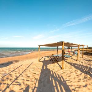 un refugio de picnic en una playa con el océano en Itaparica praia hotel, en Itaparica