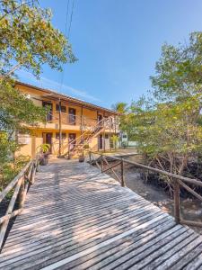 a wooden walkway in front of a building at Itaparica praia hotel in Itaparica