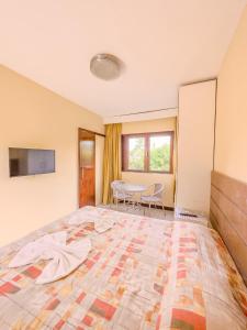 an empty room with a large bed and a table at Itaparica praia hotel in Itaparica Town