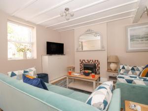 a living room with a blue couch and a fireplace at Little Gull Cottage in Weymouth