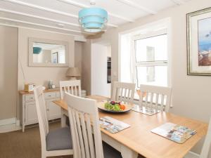 a dining room with a table with a bowl of fruit on it at Little Gull Cottage in Weymouth