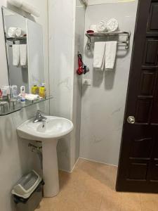 a bathroom with a sink and a mirror and towels at A25 Hotel - Đội Cấn 1 in Hanoi