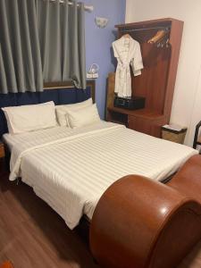 a bedroom with a bed with a shirt hanging on the wall at A25 Hotel - Đội Cấn 1 in Hanoi