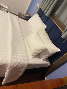 una cama con almohadas blancas encima en A25 Hotel - Đội Cấn 1, en Hanói