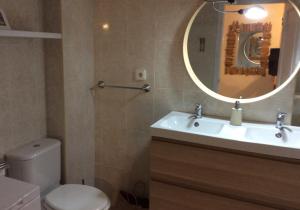 a bathroom with a sink and a toilet and a mirror at Bilocale vista mare Es Pujols in Es Pujols +40 photos