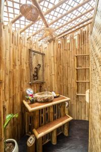 ein Holzbadezimmer mit einem Waschbecken und einer Holzwand in der Unterkunft Magical Bamboo House with Breathtaking view in Selat
