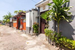 una calle con un edificio y plantas a un lado en The Backyard House, en Tabanan