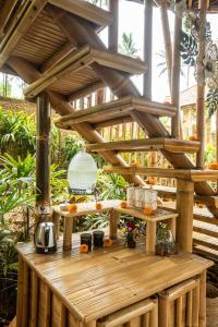 eine Holzterrasse mit einem Tisch mit Essen darauf in der Unterkunft Magical Bamboo House with Breathtaking view in Selat