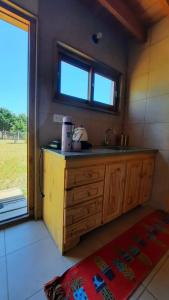 d'une cuisine avec un comptoir, un évier et une fenêtre. dans l'établissement AMARRA Camet Norte, à Santa Clara del Mar