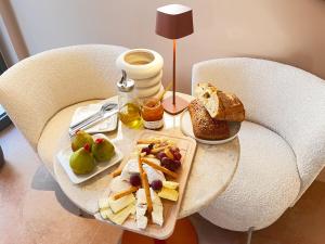 a table with a tray of food on a chair at Villa Chiesa Maison Hôtelière in Le Grau-du-Roi