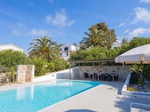 ein Swimmingpool mit Sonnenschirm und ein Haus in der Unterkunft Spectacular Son Bou Villa 3 Bedrooms Villa Carosant Panoramic Sea Views in Son Bou