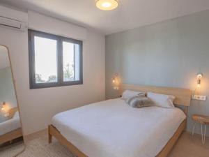 ein Schlafzimmer mit einem großen weißen Bett mit einem Fenster in der Unterkunft Spectacular Son Bou Villa 3 Bedrooms Villa Carosant Panoramic Sea Views in Son Bou