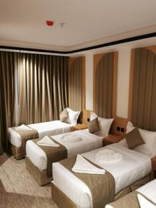 a hotel room with three beds in it at فندق سما المقام in Jarwal
