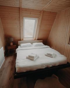 a large bed in a wooden room with a window at Atipic Chalet in Holda +32 photos