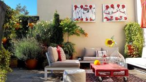 a patio with a couch and a table and plants at Veeve - Visual Exultation in Boulogne-Billancourt