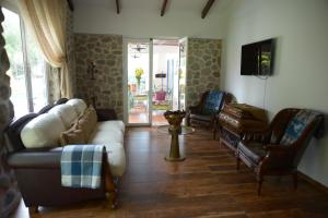 ein Wohnzimmer mit Sofas und Stühlen sowie einem TV in der Unterkunft Casa de Campo Solar Tere in Cochabamba