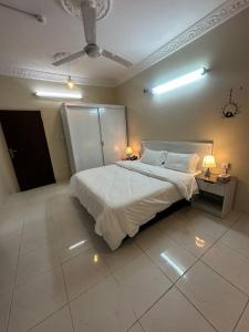 a bedroom with a large white bed with two lamps at شاليهات هدوء الشاطئ لبيوت العطلات in Ar Rukūbah