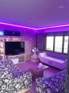 sala de estar con bañera e iluminación púrpura en La casa de ensueño, en Yeles