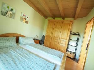 1 dormitorio con 2 camas y techo de madera en Ferienwohnung Stuiber, en Haarbach