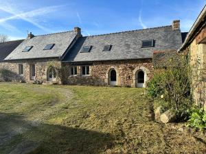 einem externen Blick auf ein Steinhaus mit Hof in der Unterkunft Le Grand Ker - Gîte de Charme in Plougasnou