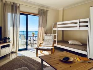 a bedroom with bunk beds and a living room with a balcony at Pérola do Algarve in Quarteira