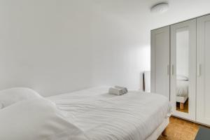 1 dormitorio blanco con 1 cama grande y espejo en The Heights of Saint-Cloud, en Saint-Cloud