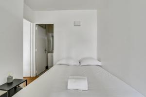 1 dormitorio blanco con 1 cama blanca grande en The Heights of Saint-Cloud, en Saint-Cloud