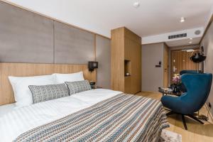 a hotel room with a bed and a blue chair at Deo Plaza Apartamenty Premium in Gdańsk