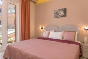 sypialnia z dużym łóżkiem i oknem w obiekcie Mary Elen Boutique Hotel w Argasio