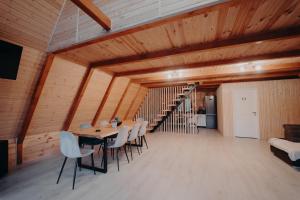 a dining room with a table and chairs and a staircase at Atipic Chalet in Holda