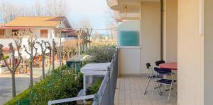 Vis Bella Apartment في ريميني: شرفة مع طاولة وكراسي على الفناء