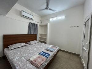 Schlafzimmer mit einem Bett und einem Deckenventilator in der Unterkunft HOMESTAY - AC 1 BHK NEAR AlRPORT in Chennai