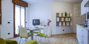 Vis Bella Apartment في ريميني: مطبخ مع طاولة وكراسي في غرفة