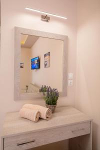 Mary Elen Boutique Hotel في أرغاسي: حوض الحمام مع مرآة ومغسلة