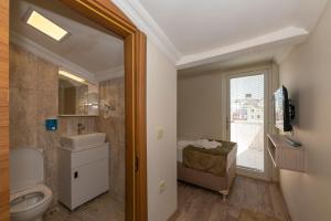 La salle de bains est pourvue de toilettes, d'un lavabo et d'une fenêtre. dans l'établissement Bazaar Hotels Old City, à Istanbul