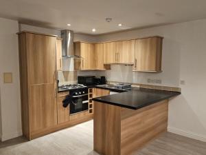 a kitchen with wooden cabinets and a black counter top at Impeccable 2-Bed House in Basildon in Basildon