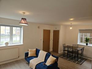 a living room with a blue couch and a table at Impeccable 2-Bed House in Basildon in Basildon