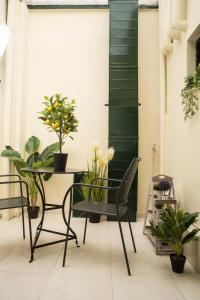 a balcony with a table and chairs and plants at Historical center small diamond in Kalamata