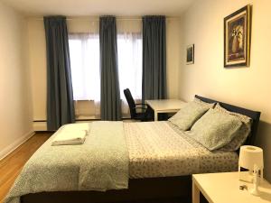 - une chambre avec un lit et un bureau dans l'établissement Big Private Room MidMontreal next to station metro - Parking free, à Montréal