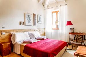 1 dormitorio con 1 cama con manta roja en Podere Castellare, en Pelago