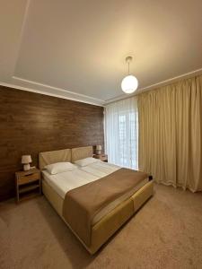 - une chambre avec un grand lit et une fenêtre dans l'établissement Garden Hall, à Ternopil