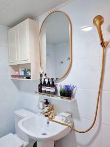 a white bathroom with a sink and a mirror at Jamsil Heaven in Seoul