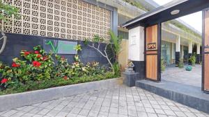 a building with flowers and plants in front of it at V Canggu Dormitory in Canggu
