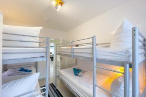 a room with three bunk beds in it at Strandstrasse 21 Ferienwohnung Möwennest in Kölpinsee