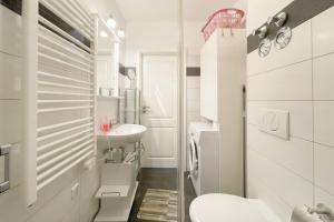 a white bathroom with a sink and a toilet at Strandstrasse 21 Ferienwohnung Möwennest in Kölpinsee +18 photos