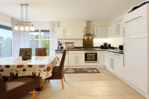 a kitchen with a table and a dining room at Strandstrasse 21 Ferienwohnung Möwennest in Kölpinsee