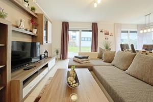 a living room with a couch and a tv at Strandstrasse 21 Ferienwohnung Möwennest in Kölpinsee