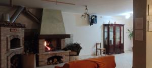 a living room with a brick fireplace with a fire at La dimora dei Sanniti in Busso