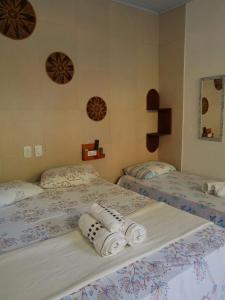 two beds in a room with towels on them at Estalagem Sol de Boipeba in Ilha de Boipeba